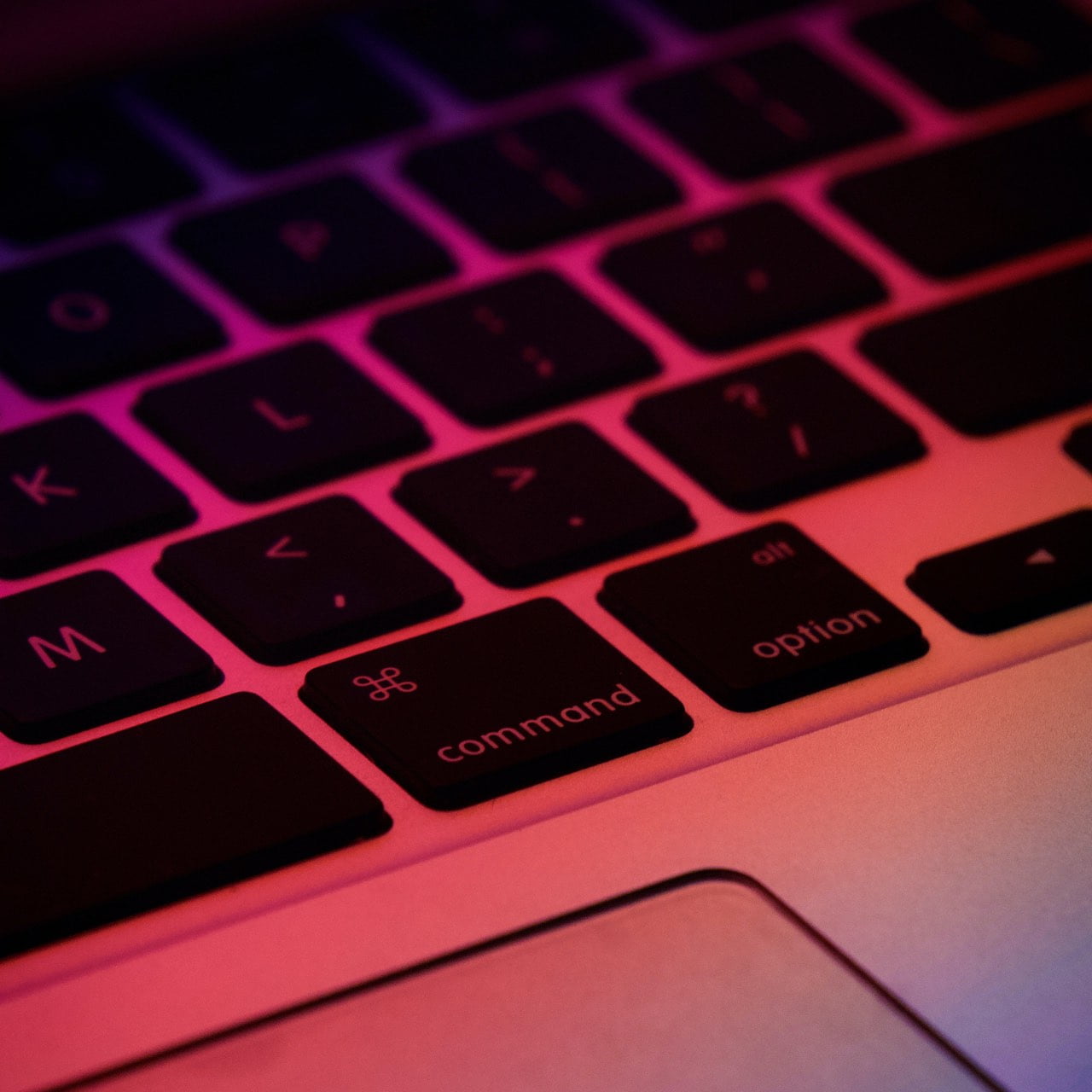 MacBook Pro Tastatur mit pinkem und violettem Licht.